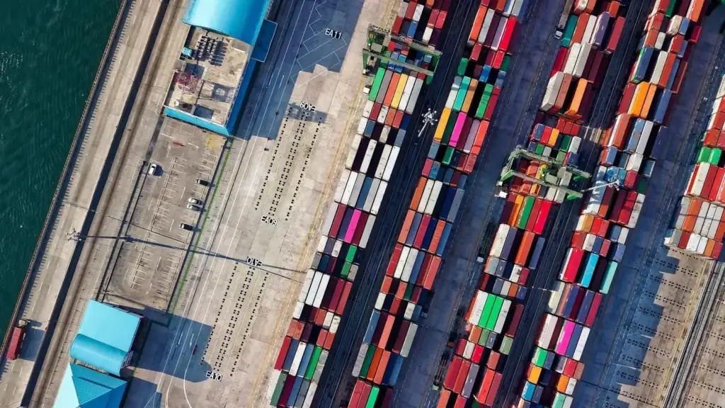 An overhead view of a bustling shipping port with numerous colorful cargo containers stacked neatly.