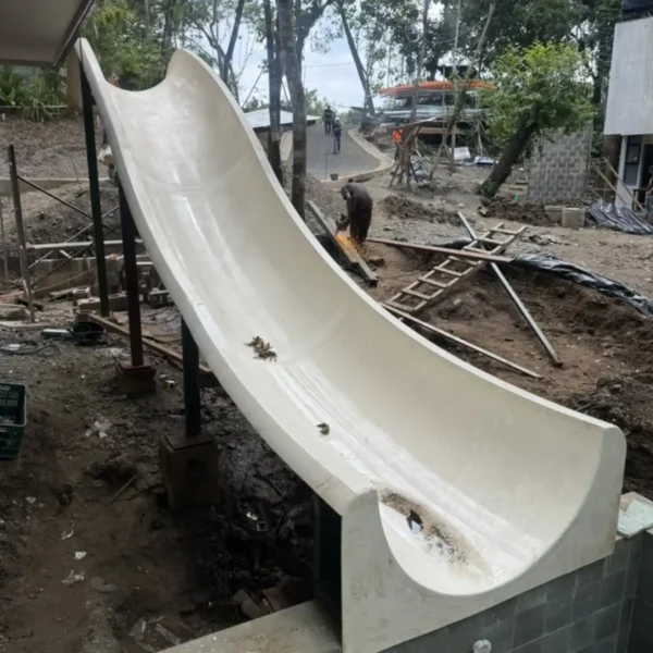 Custom concrete pool slide installation at Manuel Antonio Tree House Villa with structural anchoring and integrated plumbing connections.