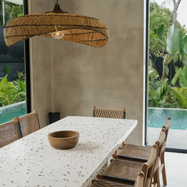 Open-concept living space at Manuel Antonio Tree House Villa with sliding glass doors leading to a private pool and custom slide.
