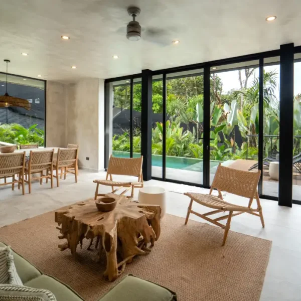 Open-concept living space at Manuel Antonio Tree House Villa with sliding glass doors leading to a private pool and custom slide.