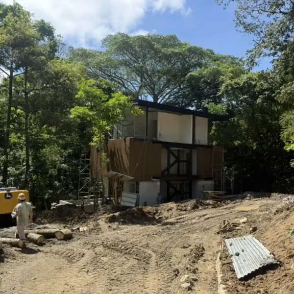 Heavy equipment performing site grading and slope stabilization at Manuel Antonio Tree House Villa construction site.